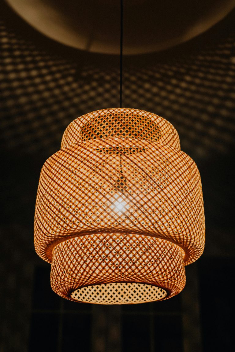 Close-up of a beautifully woven rattan pendant lamp casting a warm glow.